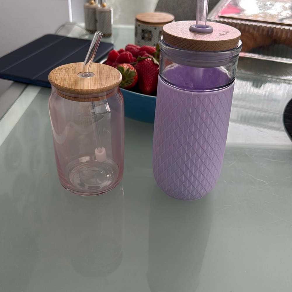 Bundle of two glass cups with lids and straws